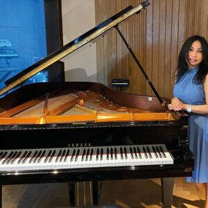 Nani in front of a piano in the studio