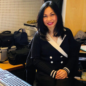 Nani in front of mixing desk in recording studio